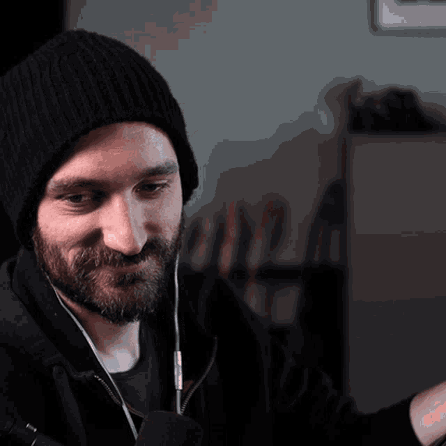 a man with a beard wearing a beanie and headphones