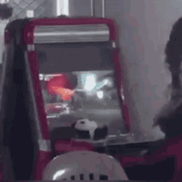 a red arcade machine is sitting on a table in a dark room