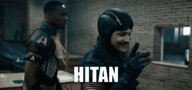 a man in a superhero costume is talking on a cell phone and the word hitan is on the screen