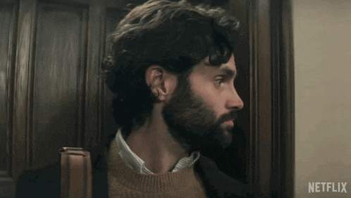 a man with a beard is standing in front of a door with a netflix logo on it
