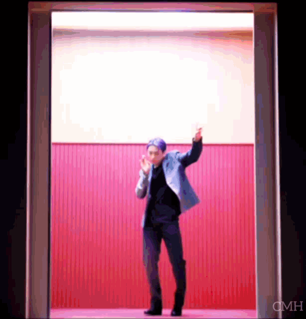 a man in a suit is standing in a doorway with his arms in the air .