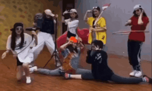 a group of people are dancing together in a room while a man takes a picture of them .