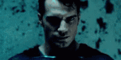a close up of a man 's face in front of a blue wall .
