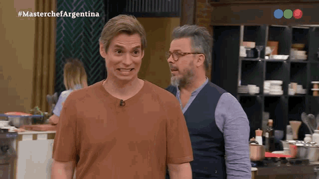 two men are standing in front of a screen that says masterchef argentina on it