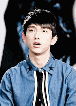 a young man wearing a blue shirt with white stars on it