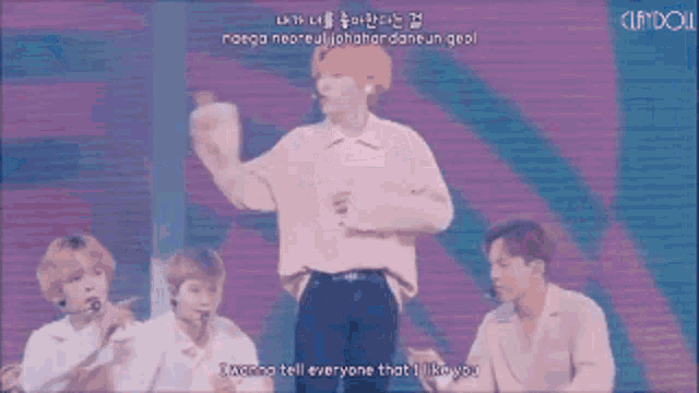 a group of people are dancing on a stage with the words i wanna tell everyone that i like you