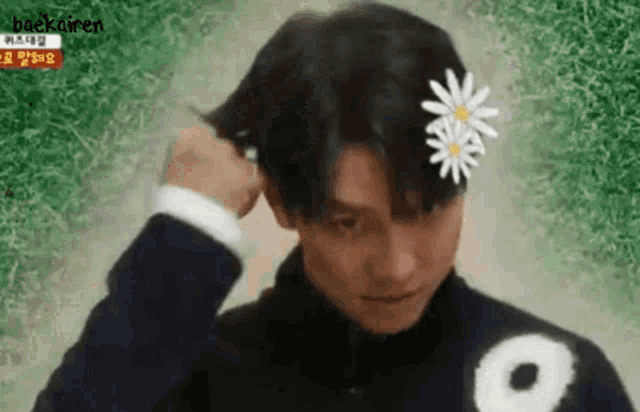 a man wearing a flower in his hair .