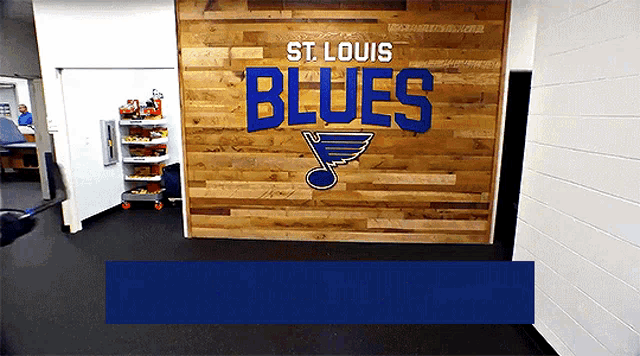 a sign for the st. louis blues is displayed on a wooden wall