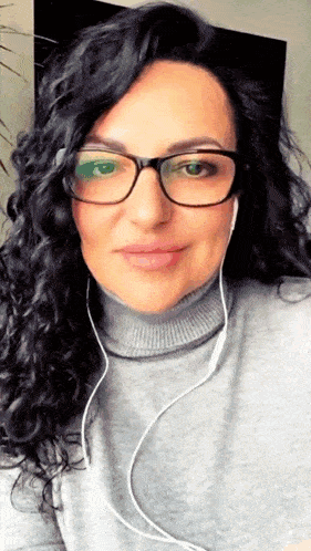 a woman wearing glasses and headphones is smiling