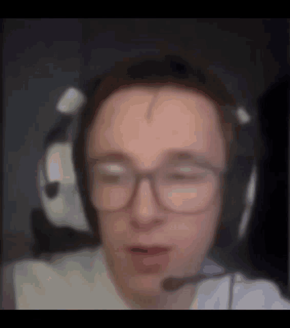 a man wearing glasses and headphones with a microphone .
