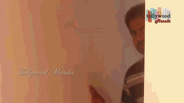 a man is standing in front of a wall with the words tollywood masala on the bottom