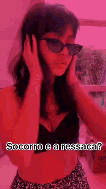 a woman wearing sunglasses and a black bra is covering her ears .