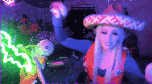 a woman is wearing a sombrero and holding a stuffed animal in front of a green light