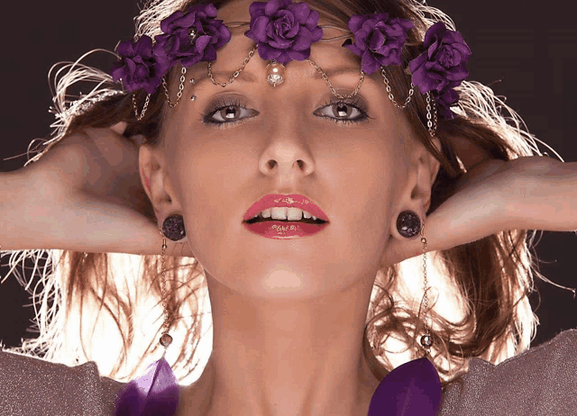 a woman with purple flowers in her hair and earrings