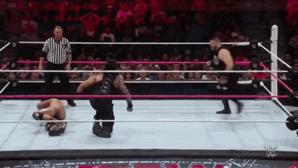a wrestling match is being played in front of a crowd .