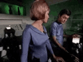 a man and woman are standing next to each other in a room .