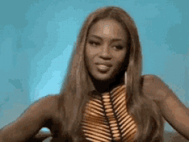 a woman with long brown hair is wearing a striped top and earrings .
