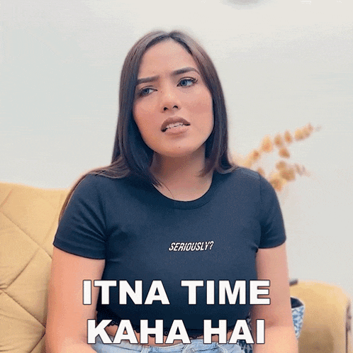 a woman wearing a black shirt that says seriously on it sits on a couch