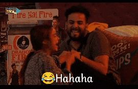 a man and woman are laughing in front of a sign that says fire hai fire