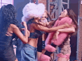 a group of women are standing next to each other on a stage and fighting .