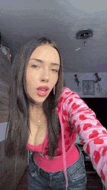 a woman wearing a pink top with hearts on it