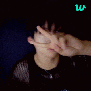 a young man giving a peace sign in front of a blue background with the letter w on it