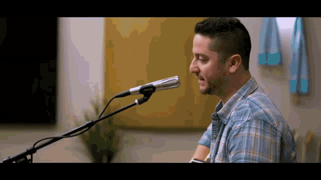 a man is singing into a microphone while playing a keyboard