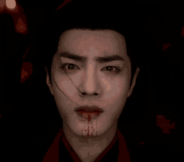a close up of a man 's face with blood on his face