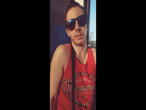 a man wearing sunglasses and a red tank top that says ' champion ' on it