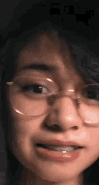 a close up of a woman 's face with glasses on