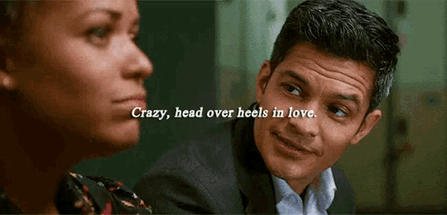 a man and a woman are looking at each other with the words crazy head over heels in love below them