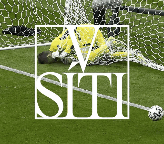 a soccer goalie is stuck in a net with the letters v and t on it