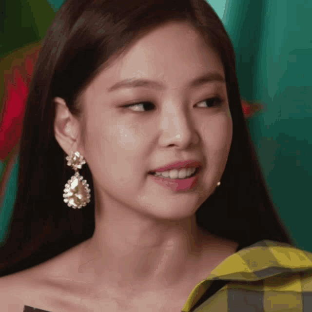 a close up of a woman wearing earrings and smiling