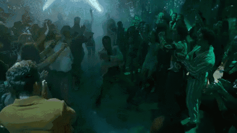 a man is dancing in a crowd of people at a party .