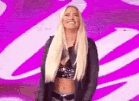 a woman with blonde hair is standing in front of a purple background .