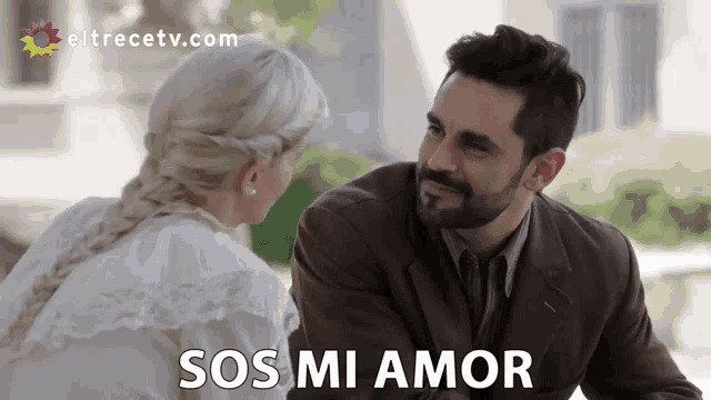 a man and a woman are looking at each other with the words sos mi amor in the corner