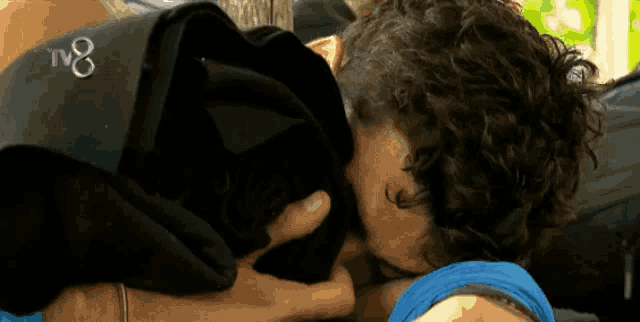 a man kissing another man with the tv8 logo on the bottom right
