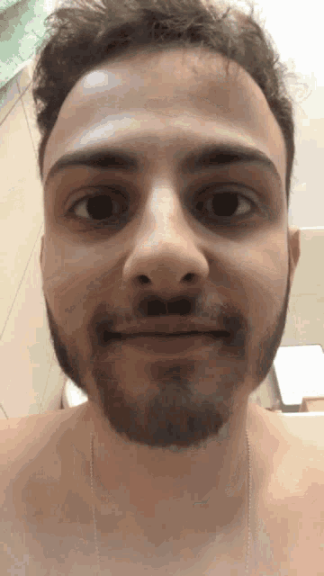 a man with a beard looks at the camera with a smile on his face