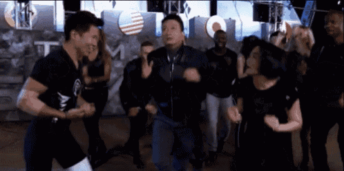a group of people are dancing in a room with a sign that says team