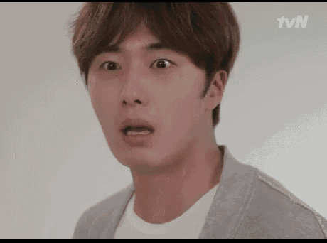 a close up of a man 's face with his mouth open and a surprised look on his face .
