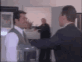 a blurry picture of two men standing next to each other in a room