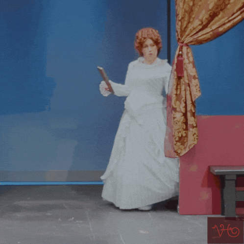 a woman in a white dress is holding a piece of paper in her hand