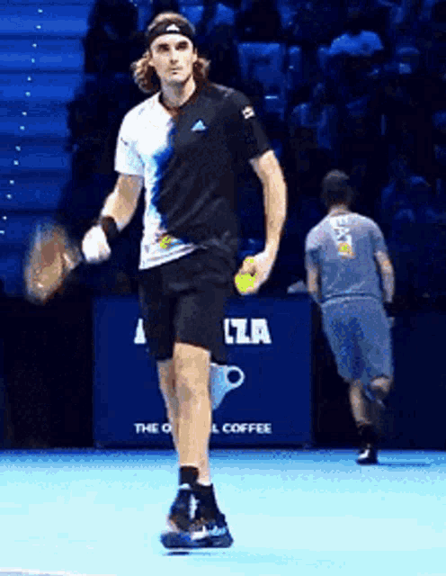 a man in a black shirt is holding a tennis racquet