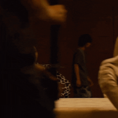 a man in a black tank top is sitting at a table