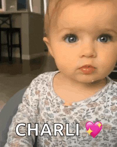 a baby with a heart and the name charli on her chest