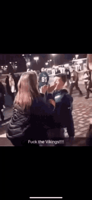 a group of people are sitting in a room and one of them says `` fuck the vikings ''
