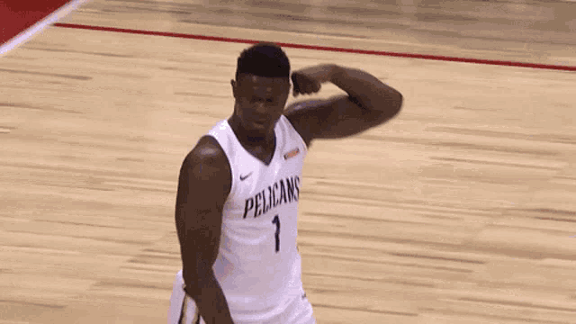 a basketball player wearing a pelican 's jersey stands on the court