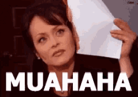 a woman is holding a piece of paper with the word muahaha on it