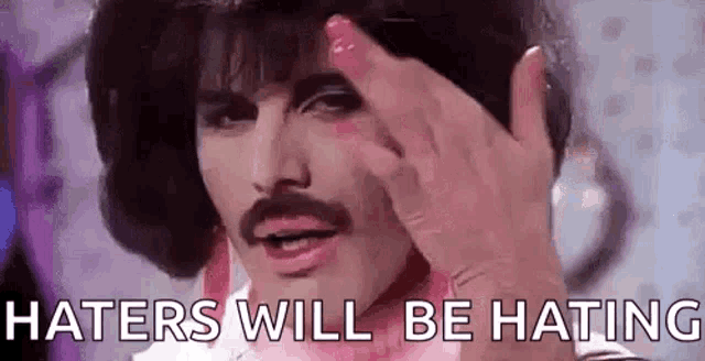 a man with a mustache and a wig is giving the middle finger .