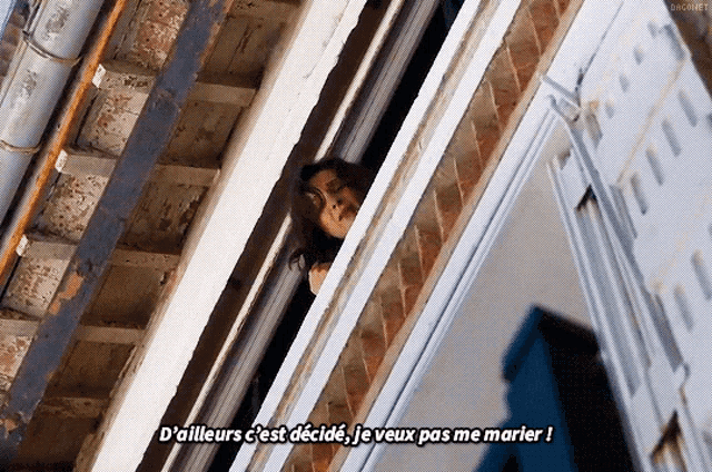a woman peeking out of a window with a caption in french